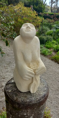 A carving in stone of a female figure looking up into the sky